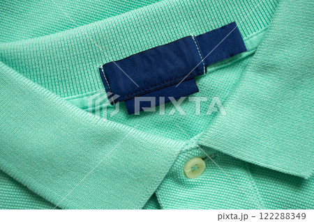 Blank blue laundry care clothes label on green shirt fabric texture background 122288349