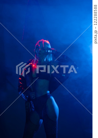 Dancer performs under colorful lights in a smoky atmosphere during a night event 122288588