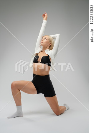 Elegant dancer stretching in a studio during a morning practice session Elegant dancer stretching in a studio during a morning practice session 122288638