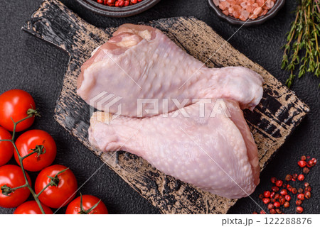 Raw chicken legs with salt, spices, herbs and tomatoes Raw chicken legs with salt, spices, herbs and tomatoes 122288876
