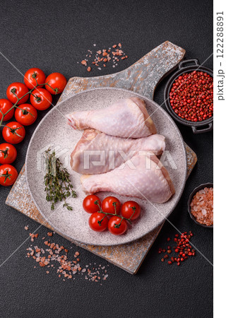 Raw chicken legs with salt, spices, herbs and tomatoes Raw chicken legs with salt, spices, herbs and tomatoes 122288891