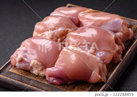 Fresh raw chicken thigh fillets with salt, spices and herbs 122288959