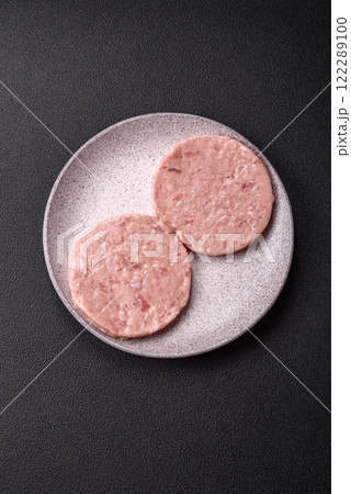 Raw chicken burger cutlet with salt, spices and herbs 122289100