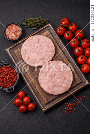 Raw chicken burger cutlet with salt, spices and herbs Raw chicken burger cutlet with salt, spices and herbs 122289121