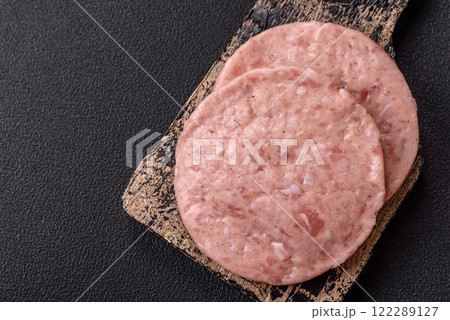 Raw chicken burger cutlet with salt, spices and herbs 122289127