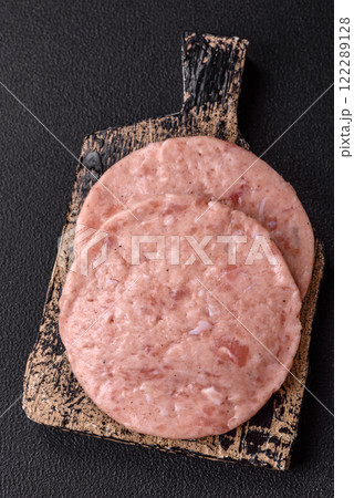 Raw chicken burger cutlet with salt, spices and herbs 122289128