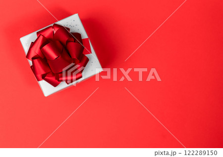 White gift box in red background. Elegant white gift box with red ribbon. Flat lay. 122289150