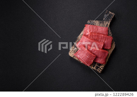 Juicy raw beef cut into slices with salt and spices Juicy raw beef cut into slices with salt and spices 122289426