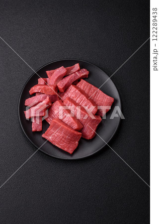 Juicy raw beef cut into slices with salt and spices 122289438