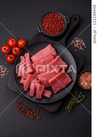 Juicy raw beef cut into slices with salt and spices Juicy raw beef cut into slices with salt and spices 122289448
