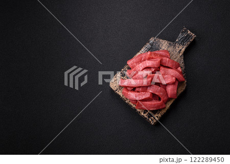 Juicy raw beef cut into slices with salt and spices Juicy raw beef cut into slices with salt and spices 122289450