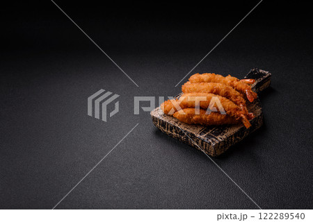 Hot crispy shrimp breaded with salt and spices with white sauce 122289540