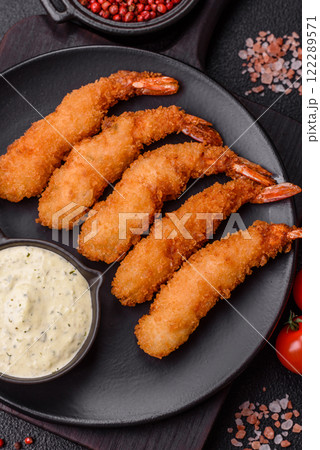 Hot crispy shrimp breaded with salt and spices with white sauce 122289571