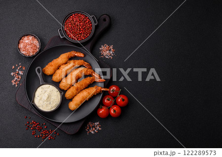 Hot crispy shrimp breaded with salt and spices with white sauce 122289573