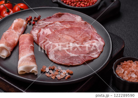 Antipasto jamon, prosciutto, sausage, sliced with tomatoes, salt and spices Antipasto jamon, prosciutto, sausage, sliced with tomatoes, salt and spices 122289590