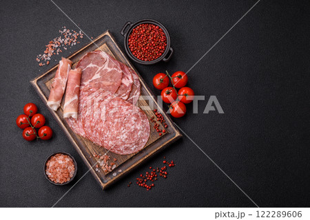Antipasto jamon, prosciutto, sausage, sliced with tomatoes, salt and spices Antipasto jamon, prosciutto, sausage, sliced with tomatoes, salt and spices 122289606