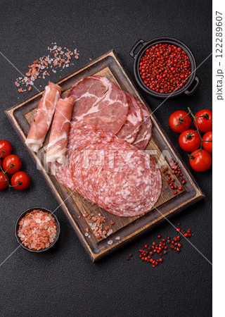 Antipasto jamon, prosciutto, sausage, sliced with tomatoes, salt and spices Antipasto jamon, prosciutto, sausage, sliced with tomatoes, salt and spices 122289607