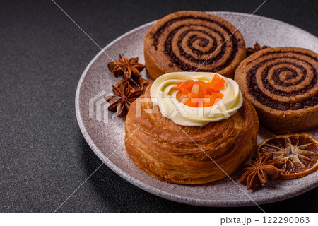 Sweet dessert danish covered with white cream and citrus, with cream filling 122290063