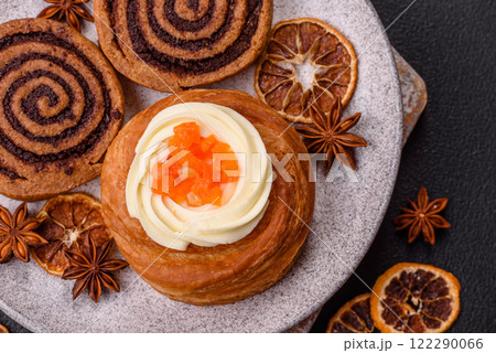 Sweet dessert danish covered with white cream and citrus, with cream filling 122290066