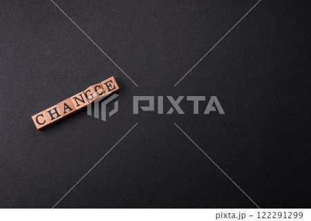 The inscription chance or change with wooden cubes on a dark concrete background 122291299