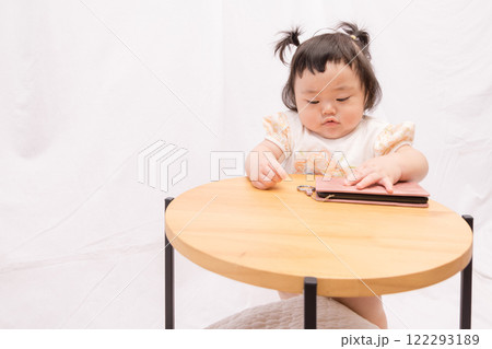 【テーブルでつかまり立ちをするツインテールの赤ちゃん スマホ】 【テーブルでつかまり立ちをするツインテールの赤ちゃん スマホ】 122293189