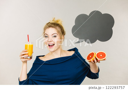 Happy woman holding fresh orange juice 122293757