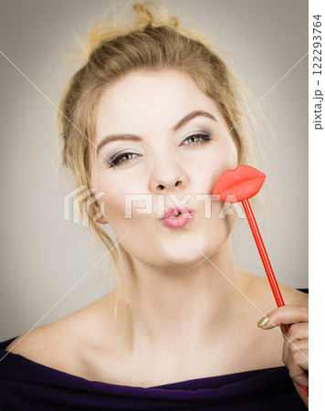 Happy woman holding lips on stick 122293764