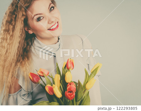 Pretty woman with red yellow tulips bunch 122293805