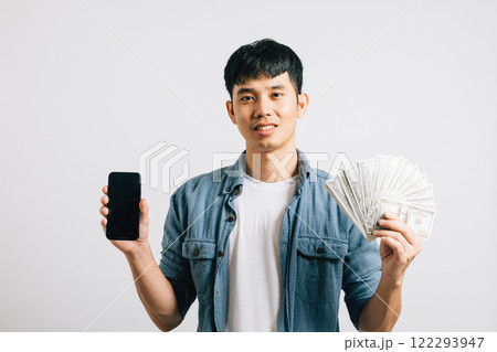Portrait smiling Asian young man holding a bunch of money and mobile phone studio shot isolated white background, happiness and excitement man in dollar banknotes with smartphone blank screen Portrait smiling Asian young man holding a bunch of money and mobile phone studio shot isolated white background, happiness and excitement man in dollar banknotes with smartphone blank screen 122293947
