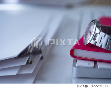 テーブルに置かれた書類とキーボードと手帳と腕時計 テーブルに置かれた書類とキーボードと手帳と腕時計 122296045