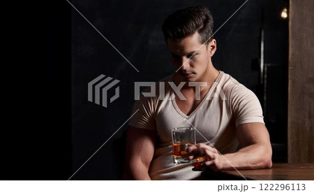 静かなバーでウイスキーを見つめる男性の渋いシーン 122296113