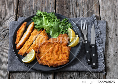 Pork Milanese with lettuce and lemon on a plate Pork Milanese with lettuce and lemon on a plate 122298623