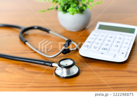 聴診器と電卓の医療費や保険料のイメージ 122298875