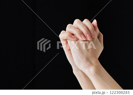 指と指が交互に組み合わされた両手 122300283