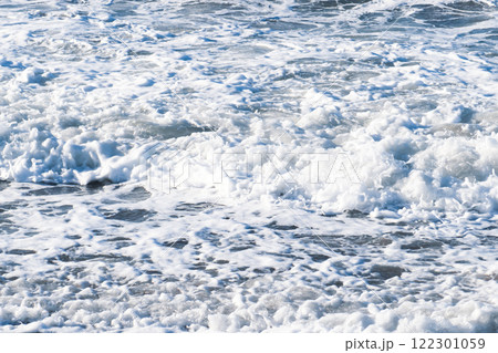 Beautiful blue sea and large calm waves and foam. Wave splashing over pebbles at sea. Rolling ocean waves. Summer paradise beach background. Powerful sea waves 122301059