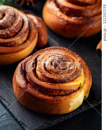 Swedish cinnamon buns or rolls. Freshly baked buns on a black stone table 122301558