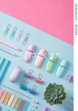 Stationery flatlay with markers, felt-tip pens, paper clips, erasers, stickers in pastel colors neatly laid on a light blue and pink background. Copyspace Stationery flatlay with markers, felt-tip pens, paper clips, erasers, stickers in pastel colors neatly laid on a light blue and pink background. Copyspace 122301610