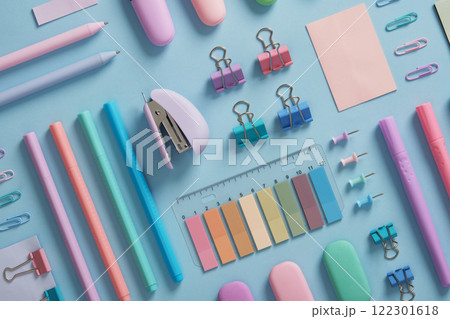 Stationery background with pastel-colored office supplies neatly arranged on a light blue background. Workplace organization. Back to school concept. 122301618