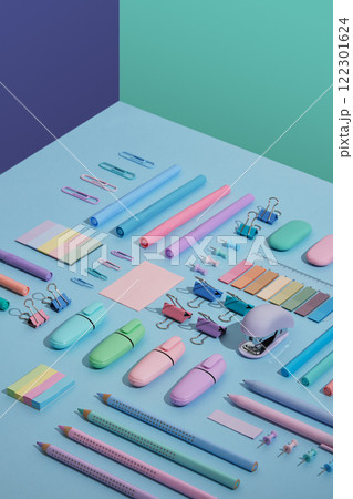 Stationery backdrop with markers, felt-tip pens, paper clips, erasers, stickers in pastel colors neatly laid on blue, mint green and violet background. Selective focus. 122301624