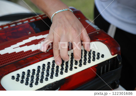 Man Testing All The Buttons Of His Accordion  122301686