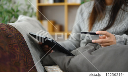 Woman holding credit card and using digital tablet. E-commerce, digital payments and online shopping concept Woman holding credit card and using digital tablet. E-commerce, digital payments and online shopping concept 122302164
