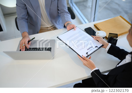 Job candidate handing over her resume during job interview Job candidate handing over her resume during job interview 122302170
