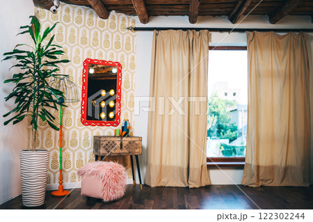 iron box on wooden legs with red frame on the wall and lamp. photo zone with mirror and table iron box on wooden legs with red frame on the wall and lamp. photo zone with mirror and table 122302244