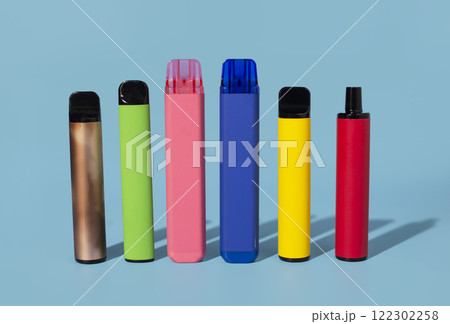 Set of colorful disposable electronic cigarettes on a blue background. The concept of modern smoking 122302258