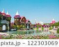 Stunning landscape of petunias set against backdrop of serene lake and cascading waterfall. Castles, buildings, airplane are made of flowers. Gardening, nature, calm atmosphere without people. Natural 122303069