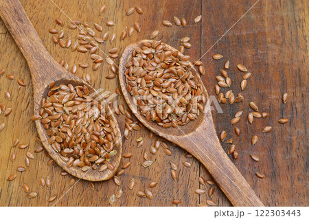 Flax seeds. Flaxseed powder in a wooden spoon. Standing on a Wooden background. 122303443
