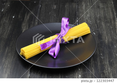 Flat lay of spaghetti for cooking italian pasta over black background. Top view of traditional italian cusine concept 122303447