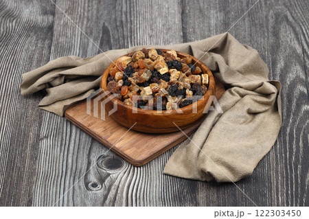 Mix of nuts and dried fruits in wooden bowl isolated on a wooden background. 122303450