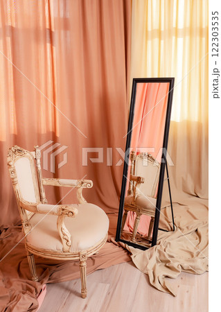 wooden chair with black mirror of colored fabrics. photo zone with pieces of fabrics and furniture wooden chair with black mirror of colored fabrics. photo zone with pieces of fabrics and furniture 122303535