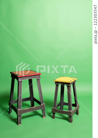 two wooden chairs on green paper background. furniture on color background 122303547